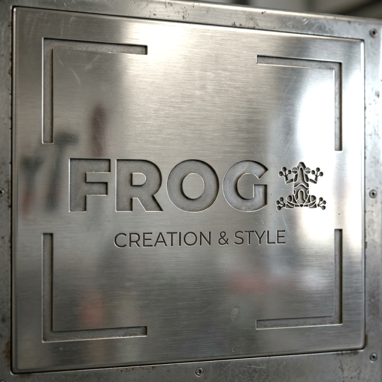 Metallene Plakette mit der Aufschrift "FROG CREATION & STYLE".