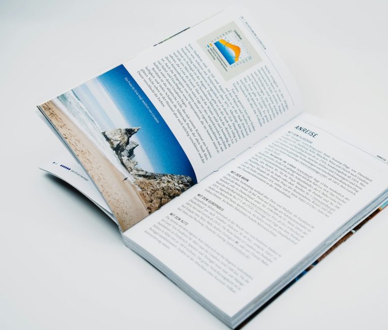 Strasser Design Ingenium – Grafikdesign, Texte, Konzepte Aufgeschlagenes Sachbuch. Weißer Hintergrund.