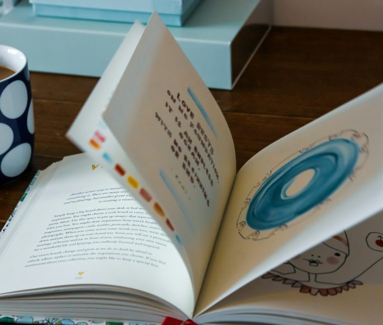Strasser Design Ingenium – Grafikdesign, Texte, Konzepte Geöffnetes Sachbuch auf einem Schreibtisch.