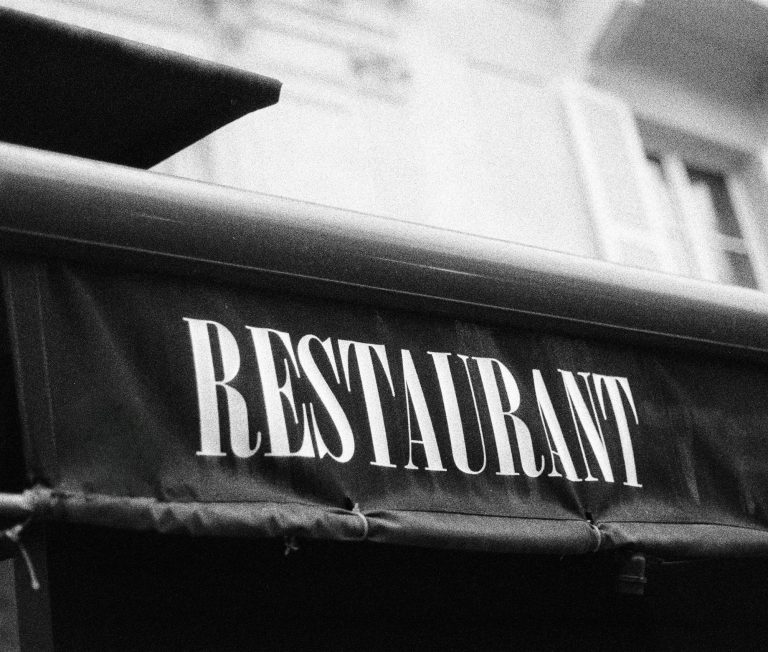 Strasser Design Ingenium – Grafikdesign, Texte, Konzepte Schwarzweißbild einer Markise mit der Aufschrift "Restaurant".