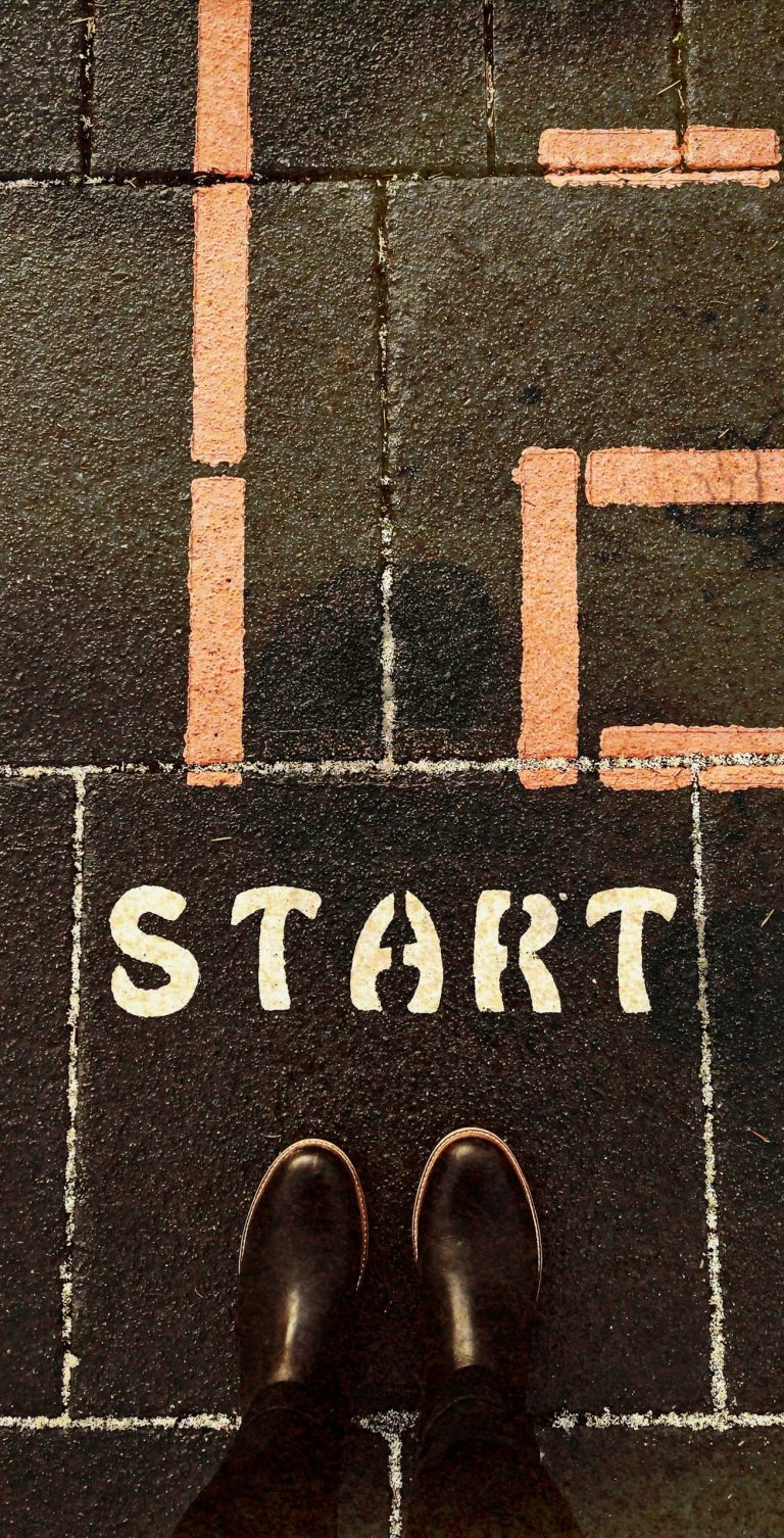 Strasser Design Ingenium – Grafikdesign, Texte, Konzepte Beine stehen auf einem schwarzen Plattenboden an einer Startlinie.