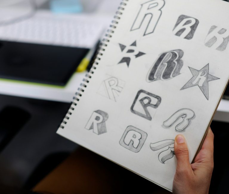 Strasser Design Ingenium – Grafikdesign, Texte, Konzepte Handgezeichnete Logoentwürfe auf einem Block.