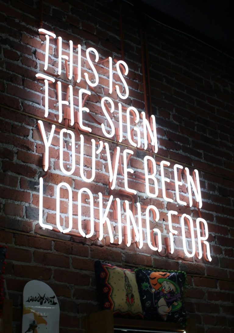 Strasser Design Ingenium – Grafikdesign, Texte, Konzepte Neonschrift vor Ziegelwand: "This is the sign you#ve been looking for".