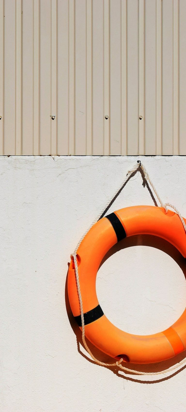 Strasser Design Ingenium – Grafikdesign, Texte, Konzepte Neonoranger Rettungsring hängt an der Wand