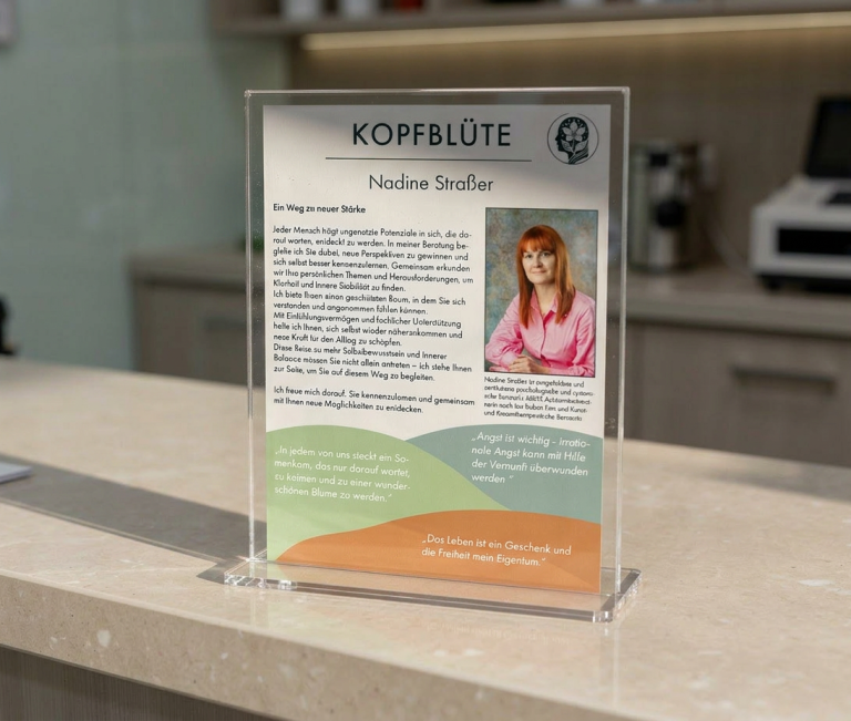Strasser Design Ingenium – Grafikdesign, Texte, Konzepte Flyer der Praxis Kopfblüte auf dem Tresen einer Arztpraxis.