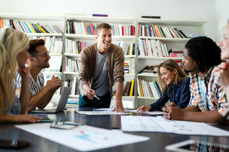 Strasser Design Ingenium – Grafikdesign, Texte, Konzepte Team junger Leute in einem Besprechungsraum.