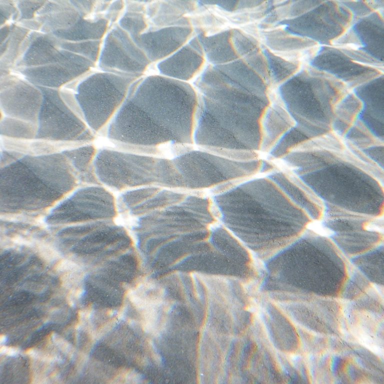 Strasser Design Ingenium – Grafikdesign, Texte, Konzepte Wasseroberfläche mit Lichtreflexen.